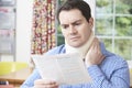 Man Reading Letter After Receiving Neck Injury