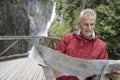 Man Reading Map Against Waterfall Royalty Free Stock Photo