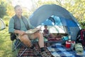 Man reading the map outside the tent at campsite Royalty Free Stock Photo