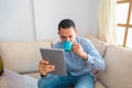 A man reading a message about an online contest on a digital tablet while drinking coffee Royalty Free Stock Photo