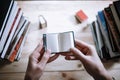 A man reading a miniature book among the big books in the library Royalty Free Stock Photo