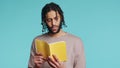 Man reading newly released hardcover book from publisher, studio background