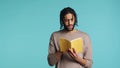 Man reading newly released hardcover book from publisher, studio background