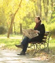 Man reading newpaper in the park