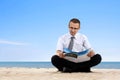 Man reading newspaper on the beach Royalty Free Stock Photo