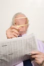 Man reading newspaper with magnifying glass Royalty Free Stock Photo