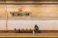Man reading a newspaper in a New York City subway station