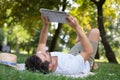 Man reading newspaper while sitting on green meadow Royalty Free Stock Photo