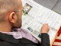 Man reading obituaries in newspaper