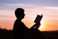 Man reading in the park against sunset Royalty Free Stock Photo