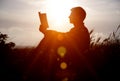 Man reading in the park against sunset. Royalty Free Stock Photo