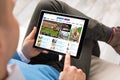 Man reading sports news on tablet. All contents are made up. Royalty Free Stock Photo