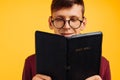 Man is reading and studying the Bible, the man is holding the Bible in his hands. Bible reading over yellow background Royalty Free Stock Photo