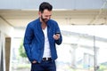 Man reading text message on mobile phone and smiling Royalty Free Stock Photo