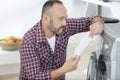 man reading washing machine instructions