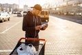 A man reads the composition of food ingredients on the packaging in the parking lot of a shopping mall or supermarket Royalty Free Stock Photo