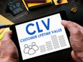 Man reads a Customer Lifetime Value CLV report on a tablet. Royalty Free Stock Photo