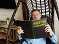 Man reads investing for beginners at home.