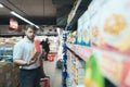 A man reads the product on a package when shopping in a supermarket. A man dies out food at the store Royalty Free Stock Photo