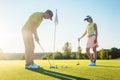 Man ready to hit the golf ball while exercising with his game partner Royalty Free Stock Photo