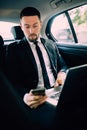 Business Man in rear of the car. Typing text message on cell phone Royalty Free Stock Photo