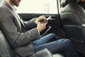 Man in rear of the car. Typing text message on mobile phone Royalty Free Stock Photo