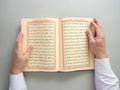 A man recites the holy Quran, verses about Ramadan fasting. Flat lay creative Ramadan Kareem concept. Islamic religion tradition. Royalty Free Stock Photo