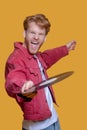 Red-haired bearded young man in red jacket with a record