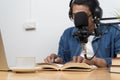 Man recording audio with microphone while reading and taking notes for educational podcast session Royalty Free Stock Photo