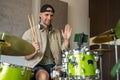 Man records drum lesson on phone and shows playing technique