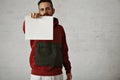 Man in red anorak with white sheet of paper