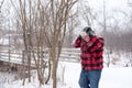 Man in red buffalo check jacket walking throught the woods on a Royalty Free Stock Photo