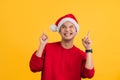 Man with red clothes celebrating the Christmas holidays standing and thinking an idea pointing the finger up on yellow background Royalty Free Stock Photo