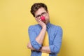 Man with red clown nose holding hand on cheek looking tired and sick Royalty Free Stock Photo