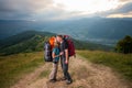 Man and red-haired woman on the road in the mountains Royalty Free Stock Photo