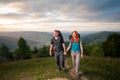Man and red-haired woman on the road in the mountains Royalty Free Stock Photo