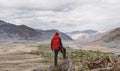 A man in red jacket standing on mountain summit, and mountains view. Travel lifestyle, adventurous, success and achievement Royalty Free Stock Photo