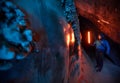 Man with red lamp in amazing blue ice cave Royalty Free Stock Photo