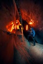 Man with red lamp in amazing blue ice cave Royalty Free Stock Photo