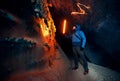 Man with red lamp in amazing blue ice cave Royalty Free Stock Photo