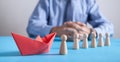 Man with a red origami paper boat and human wooden figures. Business, Leadership Royalty Free Stock Photo