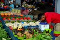 Man in red shirt behind fresh fruit vegetables stall Satok Weekend Market Kuching Sarawak Malaysia