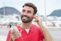 Man with red shirt and cellphone in the city loves music Royalty Free Stock Photo