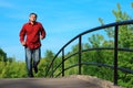 Man in red shirt runs on bridge in summer Royalty Free Stock Photo