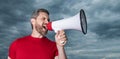 man in red shirt screaming in loudspeaker on sky background Royalty Free Stock Photo