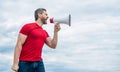 man in red shirt shouting in loudspeaker on sky background Royalty Free Stock Photo