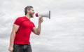 man in red shirt shouting in loudspeaker on sky background Royalty Free Stock Photo