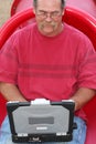 Man on red slide using laptop