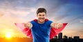 Man in red superhero cape over sunset in city Royalty Free Stock Photo