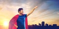 Man in red superhero cape over sunset in city Royalty Free Stock Photo